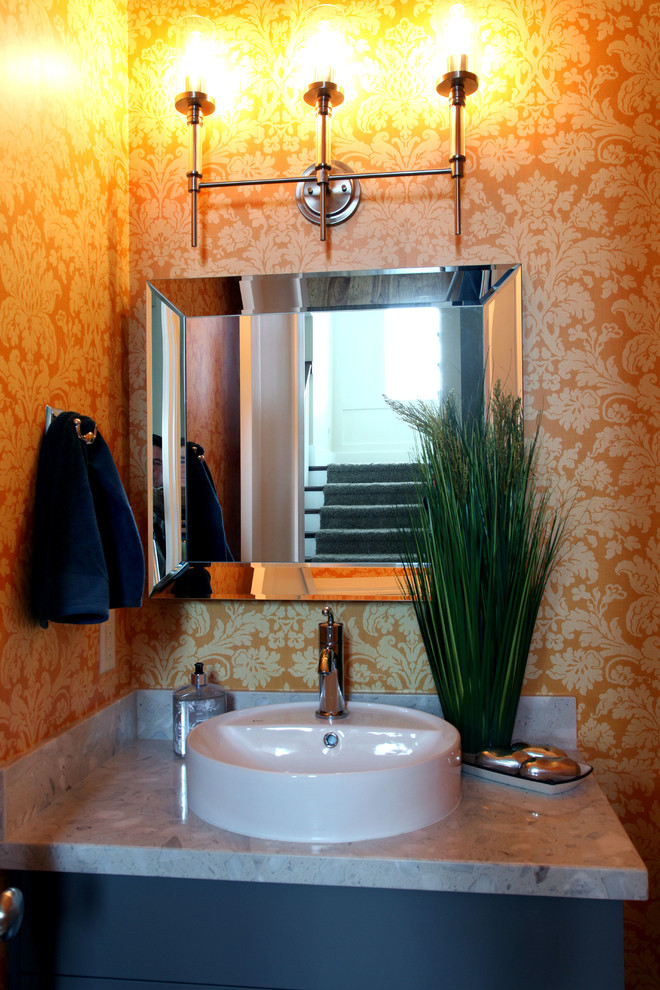 Idee per un bagno di servizio chic di medie dimensioni con lavabo a bacinella, nessun'anta, ante grigie, top in quarzo composito, pareti arancioni e pavimento in legno massello medio