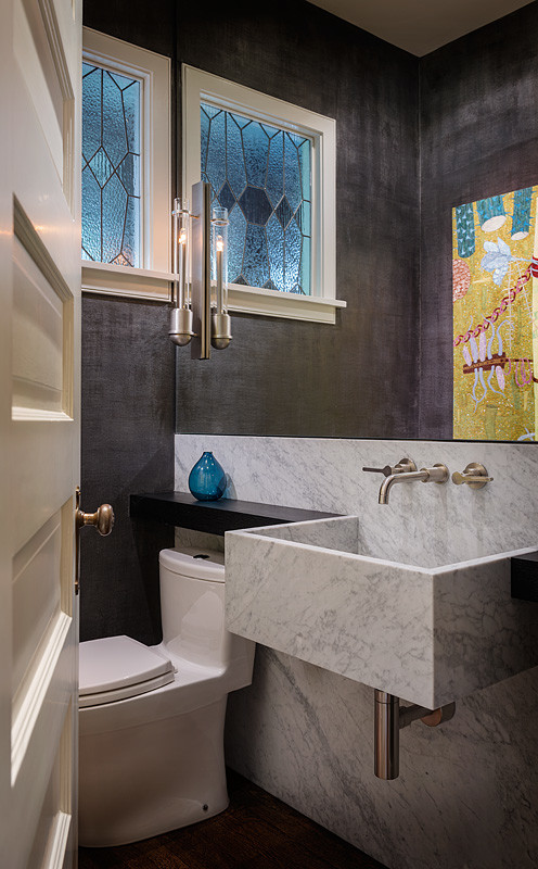Ispirazione per un bagno di servizio american style di medie dimensioni con WC a due pezzi, pareti nere, top in marmo, piastrelle grigie, piastrelle di marmo e lavabo sospeso