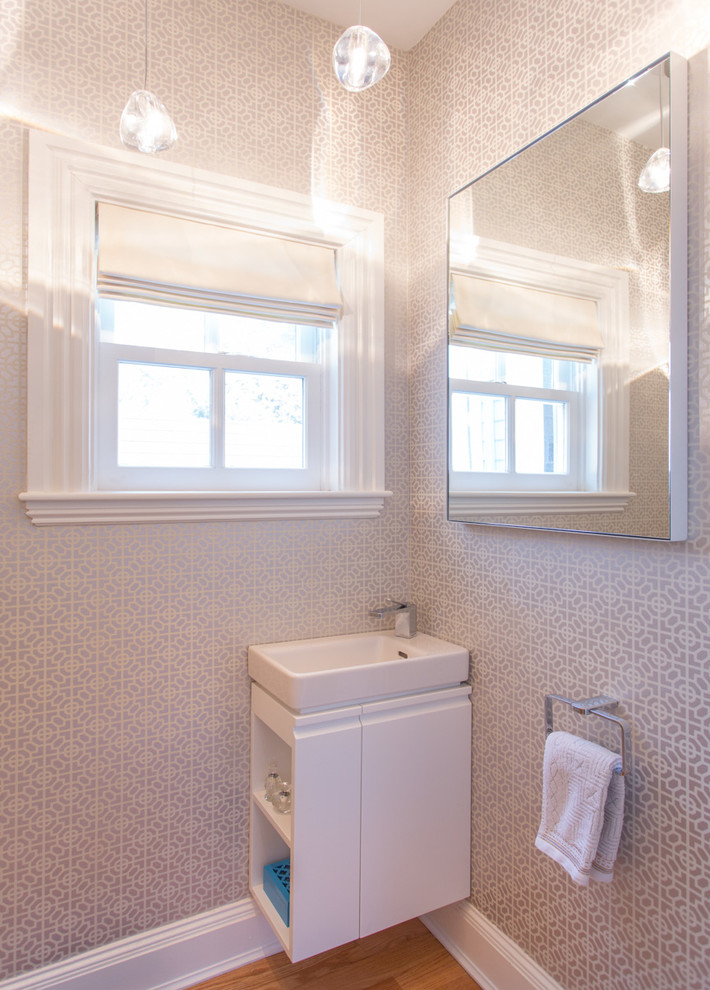 ボストンにあるラグジュアリーな小さなトランジショナルスタイルのおしゃれなトイレ・洗面所 (壁付け型シンク、フラットパネル扉のキャビネット、白いキャビネット、一体型トイレ	、淡色無垢フローリング) の写真