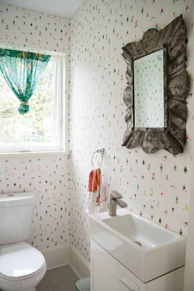 Inspiration for a small traditional cloakroom in Other with flat-panel cabinets, white cabinets, a two-piece toilet, multi-coloured walls, ceramic flooring, an integrated sink and grey floors.