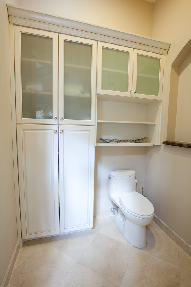 Mittelgroße Klassische Gästetoilette mit profilierten Schrankfronten, weißen Schränken, Toilette mit Aufsatzspülkasten, weißer Wandfarbe, Travertin und beigem Boden in Miami