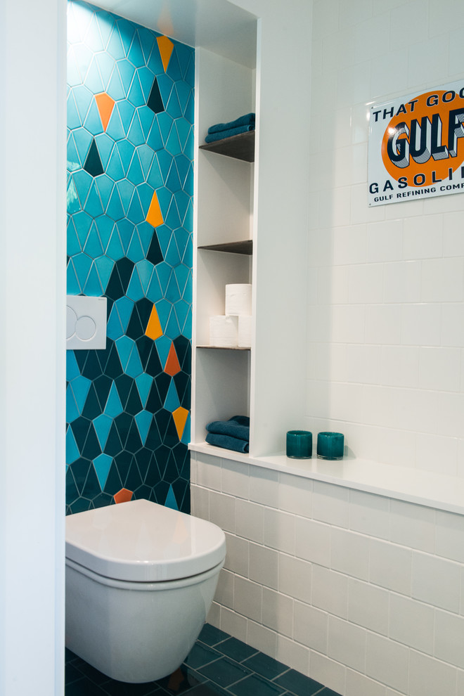 Moderne Gästetoilette mit offenen Schränken, Wandtoilette, blauen Fliesen, orangen Fliesen, weißen Fliesen, weißer Wandfarbe und blauem Boden in Austin