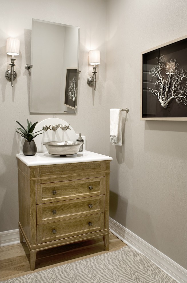 Klassisk inredning av ett mellanstort toalett, med möbel-liknande, skåp i mellenmörkt trä, en toalettstol med separat cisternkåpa, beige väggar, ljust trägolv, ett fristående handfat och bänkskiva i kvartsit
