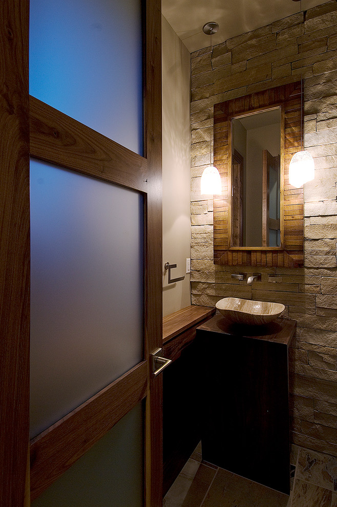 Esempio di un piccolo bagno di servizio design con lavabo a bacinella, top in legno, WC a due pezzi, piastrelle beige, piastrelle in pietra, pareti beige e top marrone