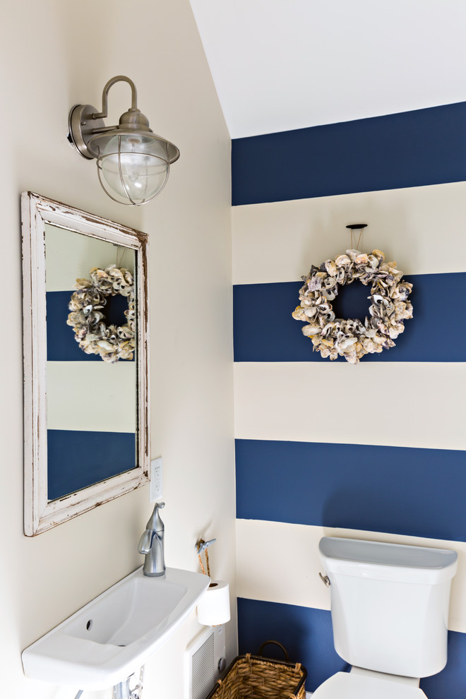 Example of a mid-sized beach style powder room design in Boston with a two-piece toilet, multicolored walls and a wall-mount sink