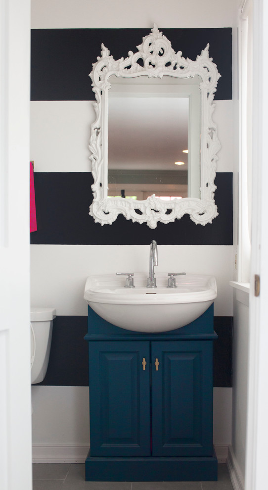 This is an example of a small bohemian cloakroom in Philadelphia with freestanding cabinets, blue cabinets, multi-coloured walls, porcelain flooring, a built-in sink and grey floors.