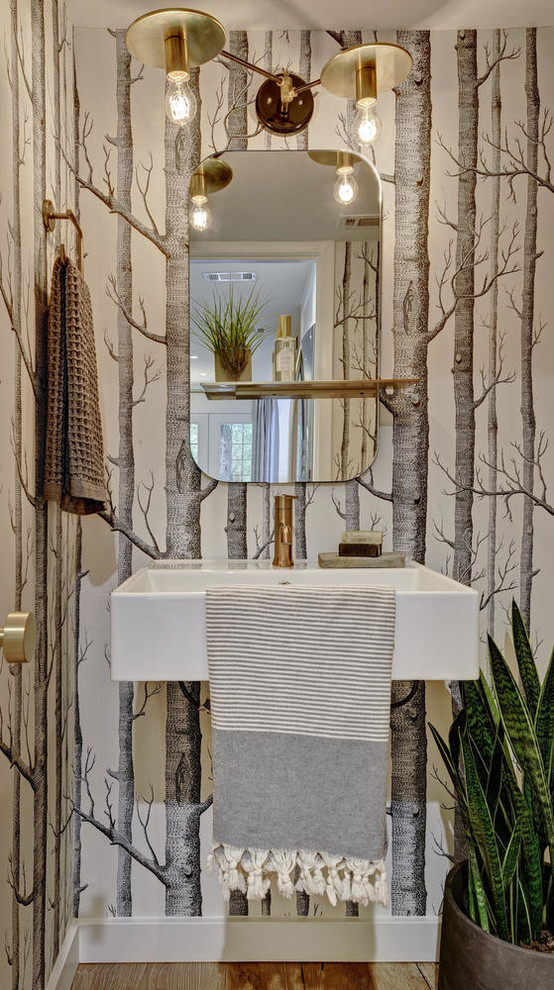 Esempio di un piccolo bagno di servizio minimalista con parquet chiaro, lavabo sospeso, pareti multicolore, top in superficie solida e pavimento beige