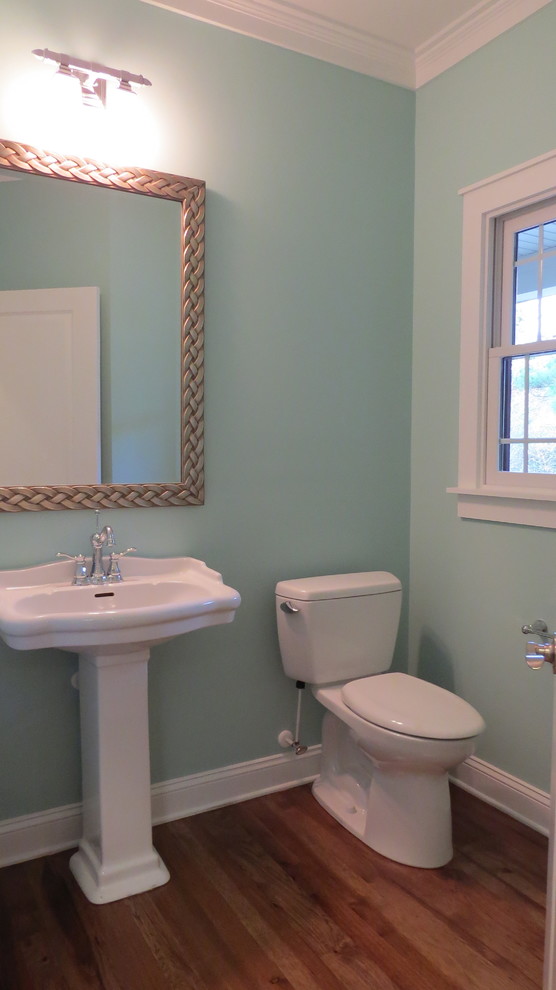 Idéer för ett stort amerikanskt toalett, med en toalettstol med separat cisternkåpa, gröna väggar, mellanmörkt trägolv och ett piedestal handfat