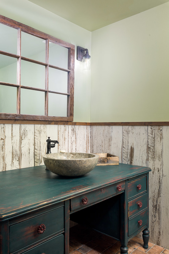 This is an example of a medium sized rustic cloakroom in Jackson with freestanding cabinets, distressed cabinets, a two-piece toilet, multi-coloured tiles, porcelain tiles, green walls, porcelain flooring, wooden worktops, orange floors, green worktops and a vessel sink.