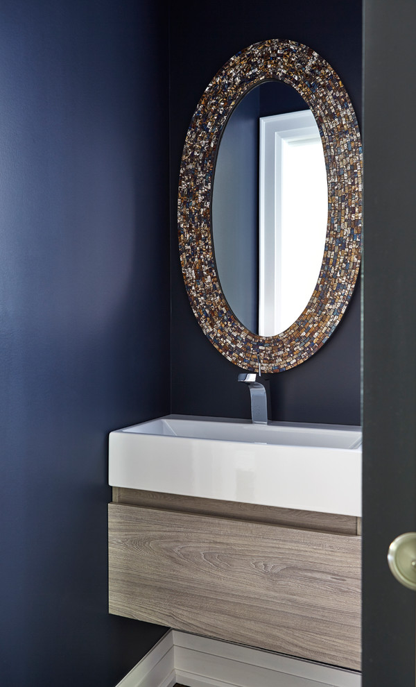 Foto på ett litet eklektiskt toalett, med möbel-liknande, skåp i slitet trä, en toalettstol med hel cisternkåpa, blå väggar, mellanmörkt trägolv, ett integrerad handfat och brunt golv