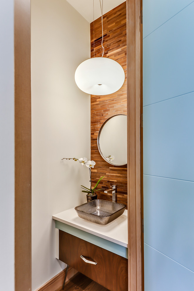 Mittelgroße Moderne Gästetoilette mit verzierten Schränken, braunen Fliesen, Stäbchenfliesen, weißer Wandfarbe, Aufsatzwaschbecken, Quarzwerkstein-Waschtisch, braunem Boden, dunklen Holzschränken und dunklem Holzboden in Calgary