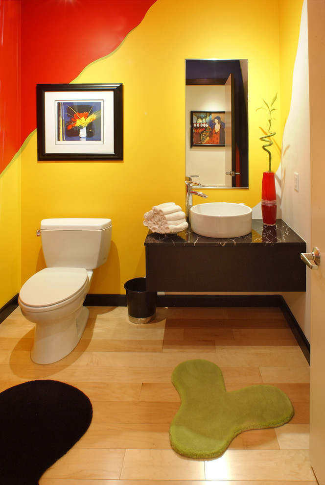 Источник вдохновения для домашнего уюта: туалет среднего размера в современном стиле с плоскими фасадами, черными фасадами, раздельным унитазом, желтой плиткой, светлым паркетным полом, настольной раковиной, мраморной столешницей, желтым полом и черной столешницей