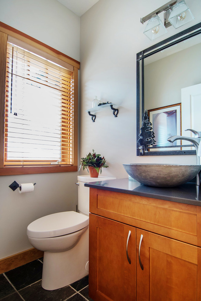 Aménagement d'un grand WC et toilettes contemporain en bois brun avec un placard à porte shaker, un sol en ardoise, une vasque, un plan de toilette en quartz modifié, WC séparés et un mur blanc.