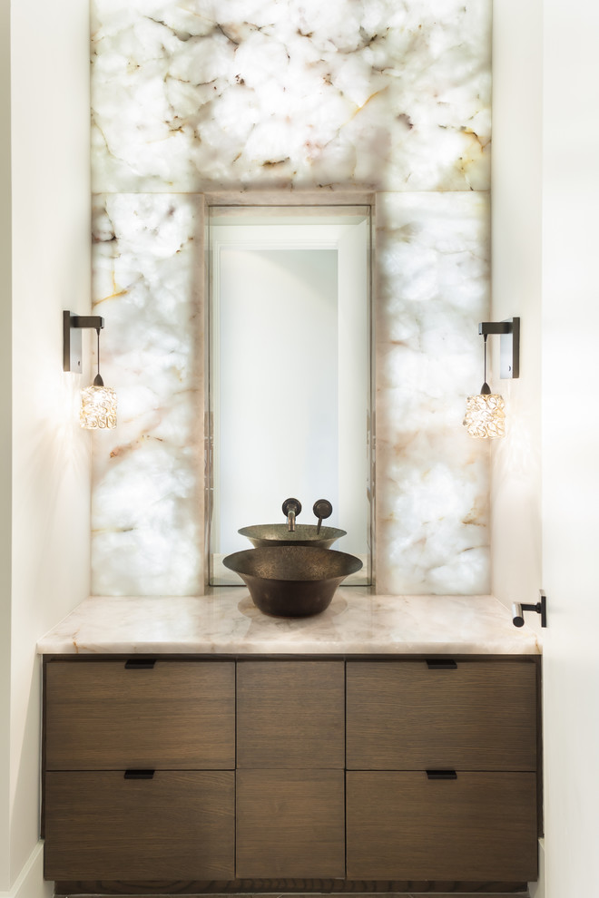 Inspiration for a contemporary white tile and stone slab powder room remodel in Houston with a vessel sink, flat-panel cabinets, dark wood cabinets, white walls and beige countertops