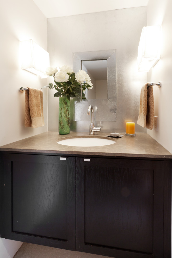 Inredning av ett modernt mellanstort toalett, med ett undermonterad handfat, skåp i shakerstil, skåp i mörkt trä, bänkskiva i kalksten, en toalettstol med hel cisternkåpa, vita väggar och betonggolv