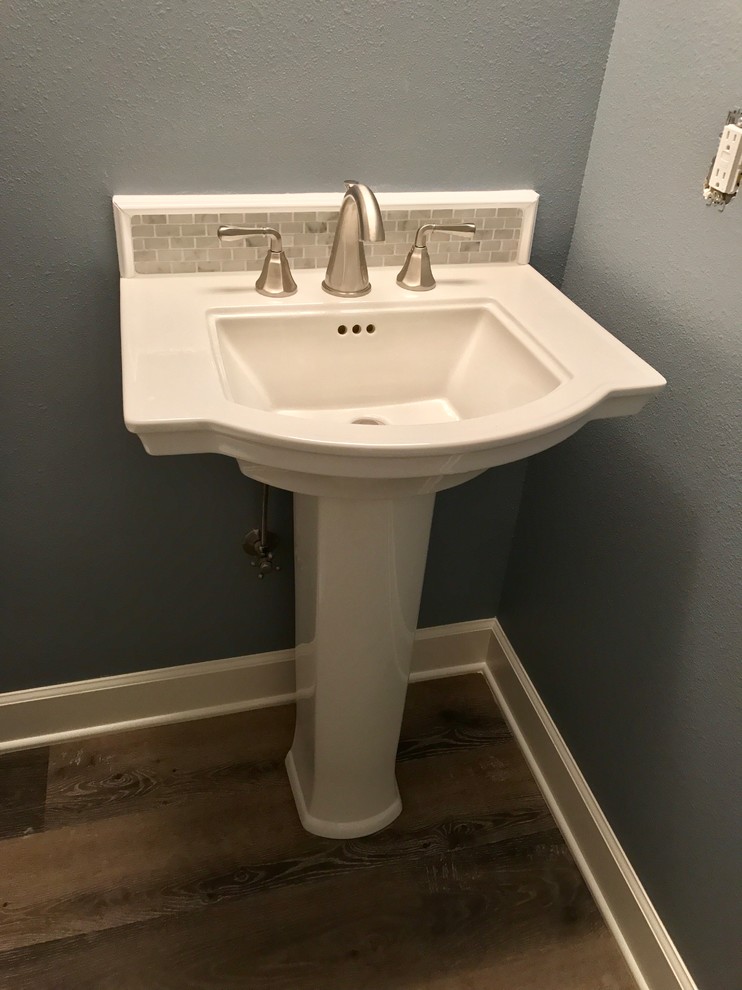 Example of a small classic white tile and marble tile laminate floor and multicolored floor powder room design in Portland with a two-piece toilet, blue walls and a pedestal sink