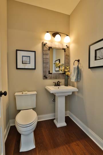 Diseño de aseo tradicional de tamaño medio con lavabo con pedestal, paredes beige, suelo de madera en tonos medios y sanitario de dos piezas