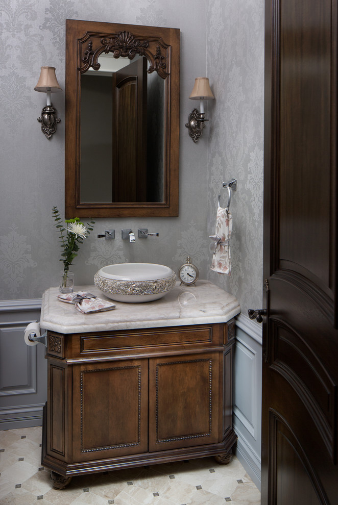 Powder room - mid-sized french country marble floor and beige floor powder room idea in Chicago with furniture-like cabinets, dark wood cabinets, gray walls, a vessel sink and marble countertops