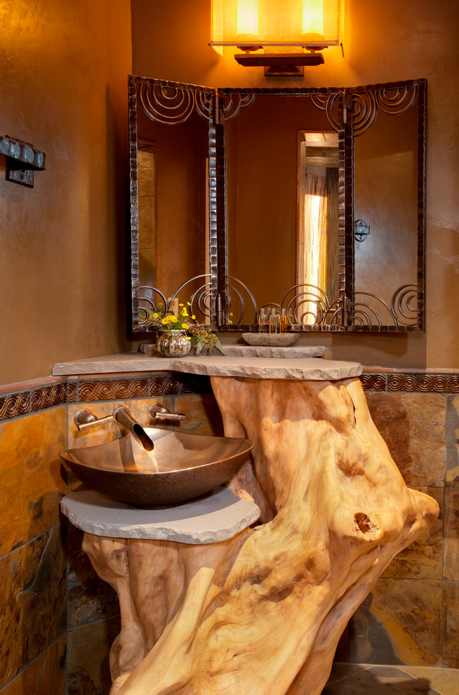 Powder room - mid-sized southwestern beige tile powder room idea in Albuquerque with a vessel sink and brown walls