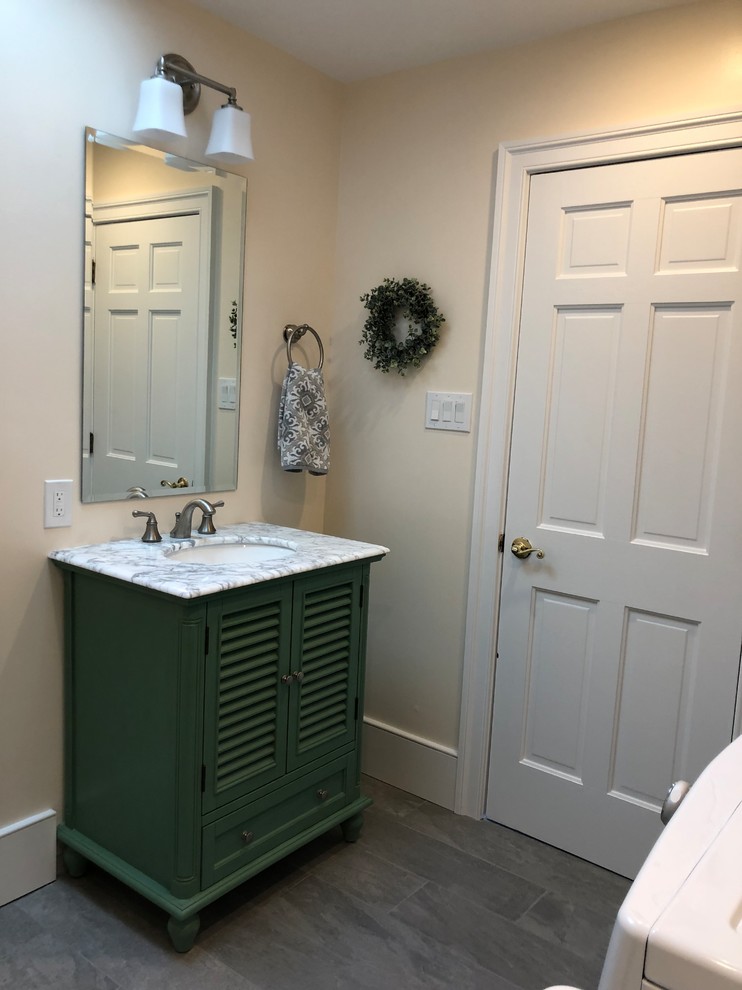 Inspiration for a medium sized country cloakroom in Philadelphia with louvered cabinets, green cabinets, a two-piece toilet, white walls, ceramic flooring, a submerged sink, marble worktops, grey floors and white worktops.