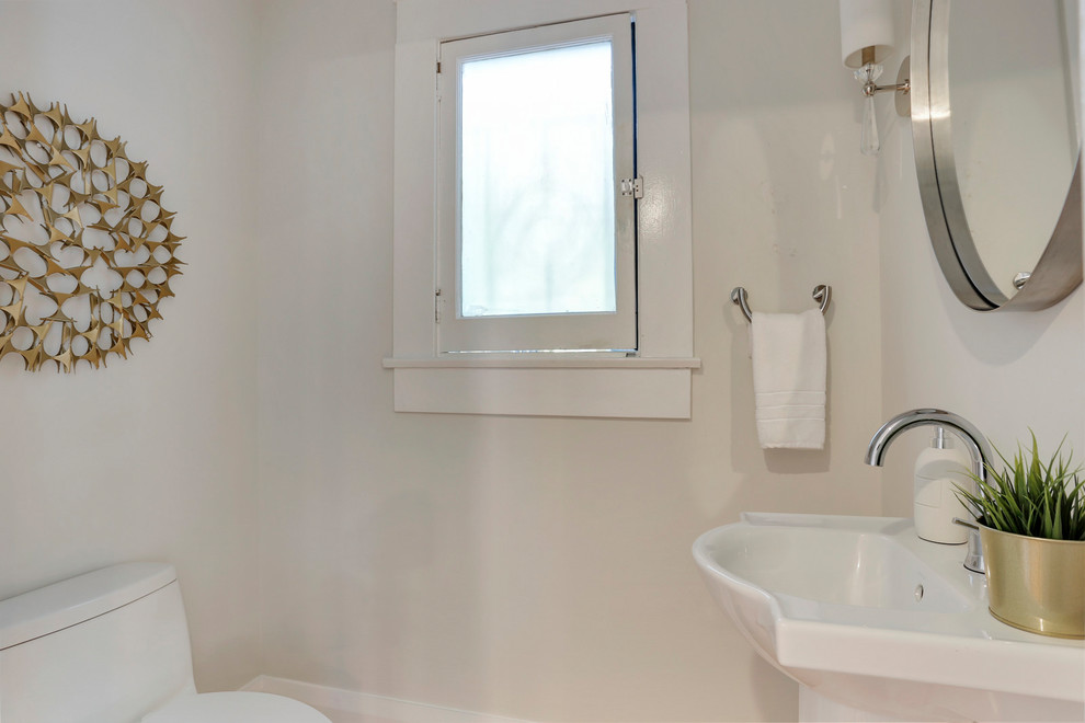 タンパにある高級な小さなトランジショナルスタイルのおしゃれなトイレ・洗面所 (一体型トイレ	、白い壁、淡色無垢フローリング、ペデスタルシンク) の写真
