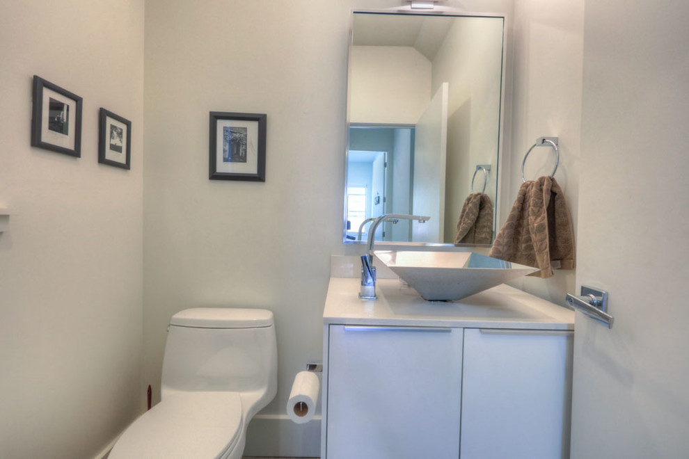 Kleine Retro Gästetoilette mit flächenbündigen Schrankfronten, weißen Schränken, Toilette mit Aufsatzspülkasten, weißer Wandfarbe, Aufsatzwaschbecken und Quarzwerkstein-Waschtisch in Houston