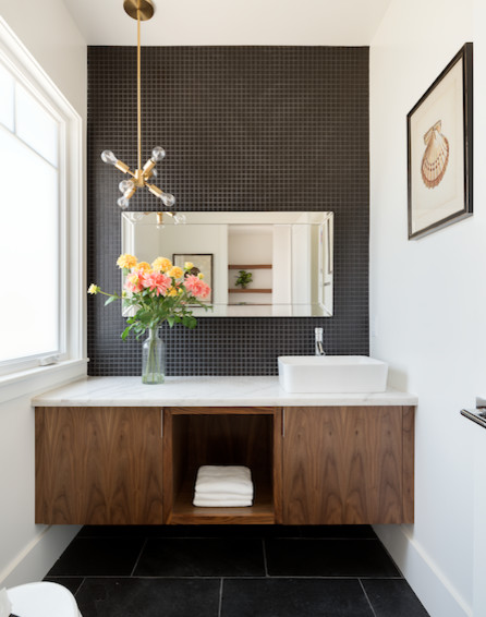 Powder room - mid-sized transitional black tile and mosaic tile porcelain tile powder room idea in Los Angeles with flat-panel cabinets, medium tone wood cabinets, a two-piece toilet, white walls, a vessel sink and marble countertops