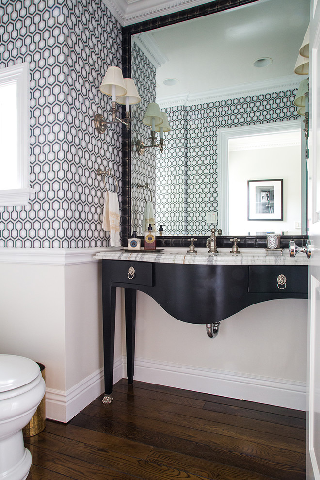 Immagine di un piccolo bagno di servizio classico con lavabo sottopiano, consolle stile comò, ante nere, top in marmo, pareti multicolore e parquet scuro