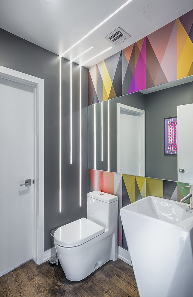 Стильный дизайн: туалет в современном стиле с разноцветными стенами, паркетным полом среднего тона, раковиной с пьедесталом и коричневым полом - последний тренд
