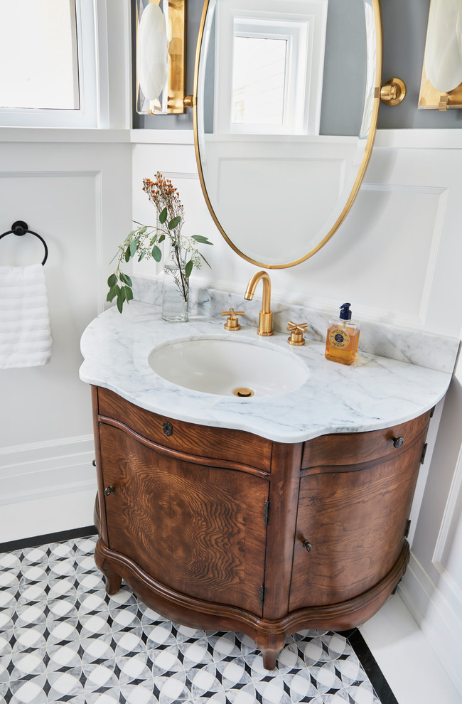 Inspiration for a mid-sized transitional gray tile mosaic tile floor and white floor powder room remodel in Toronto with furniture-like cabinets, brown cabinets, a one-piece toilet, an undermount sink and marble countertops