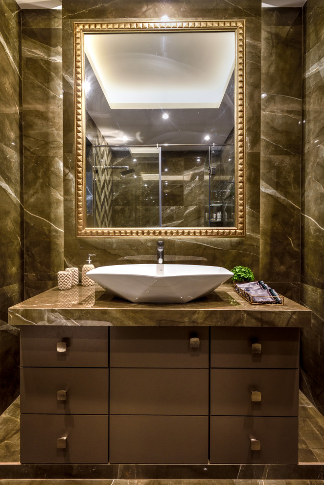 Mittelgroße Moderne Gästetoilette mit flächenbündigen Schrankfronten, grauen Schränken, grauen Fliesen, Aufsatzwaschbecken, grauem Boden, grauer Waschtischplatte und eingebautem Waschtisch in Mumbai