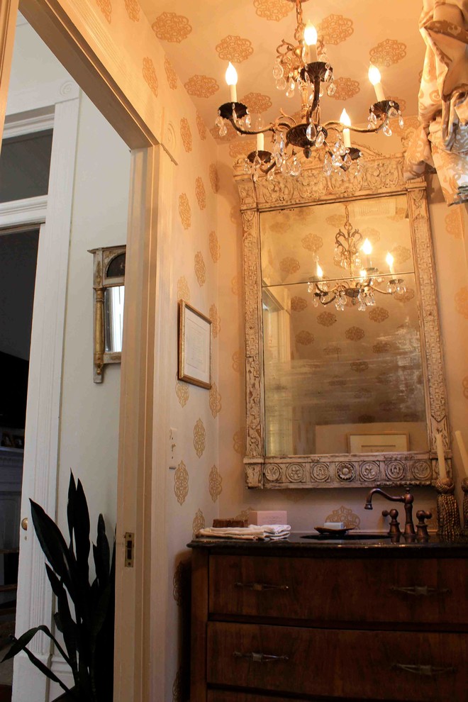 Esempio di un bagno di servizio boho chic di medie dimensioni con consolle stile comò, ante in legno bruno, lavabo sottopiano, top in granito e pareti beige