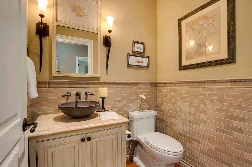 Foto di un bagno di servizio minimalista di medie dimensioni con lavabo a bacinella, ante con bugna sagomata, ante beige, top in marmo, WC monopezzo, piastrelle beige, piastrelle in ceramica e pareti beige
