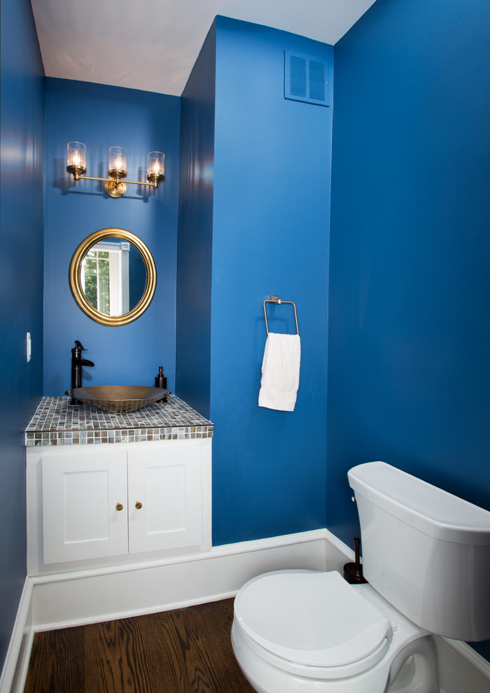 Bild på ett vintage flerfärgad flerfärgat toalett, med ett fristående handfat, skåp i shakerstil, vita skåp, kaklad bänkskiva, en toalettstol med separat cisternkåpa, flerfärgad kakel, mosaik, blå väggar och mörkt trägolv