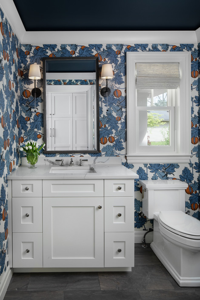 Стильный дизайн: туалет среднего размера в стиле неоклассика (современная классика) с белыми фасадами, унитазом-моноблоком, врезной раковиной, мраморной столешницей, белой столешницей, фасадами в стиле шейкер, разноцветными стенами и серым полом - последний тренд