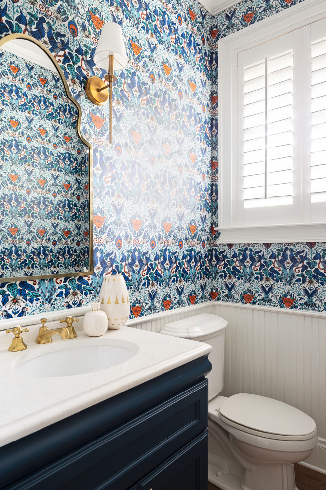 Esempio di un bagno di servizio classico con ante con riquadro incassato, ante blu, pareti multicolore, parquet scuro, lavabo sottopiano, pavimento marrone e top bianco