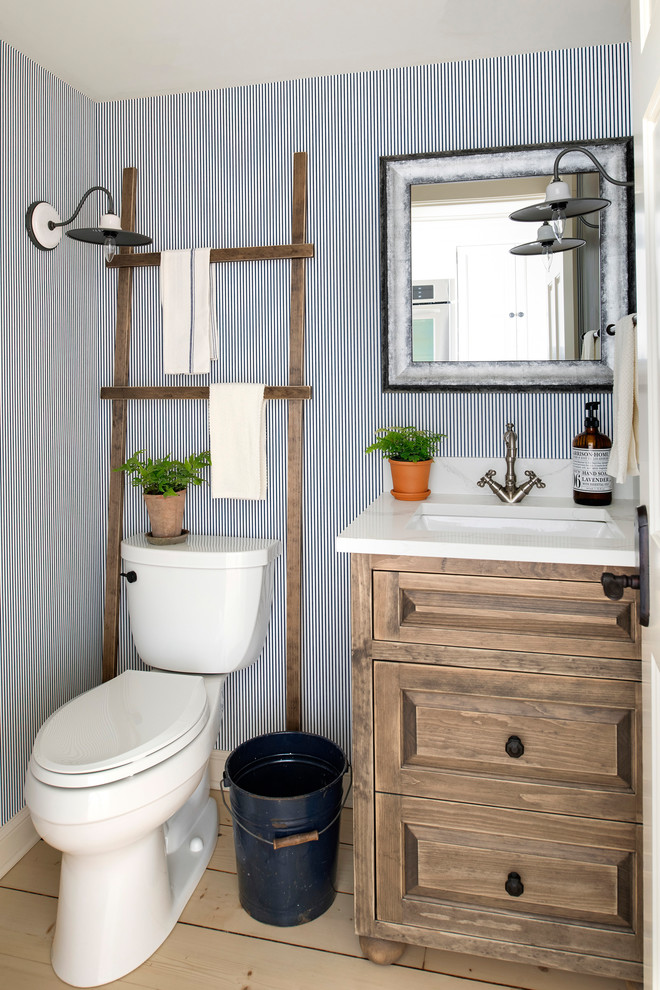 Inspiration for a cottage powder room remodel in Minneapolis with medium tone wood cabinets, a one-piece toilet and blue walls