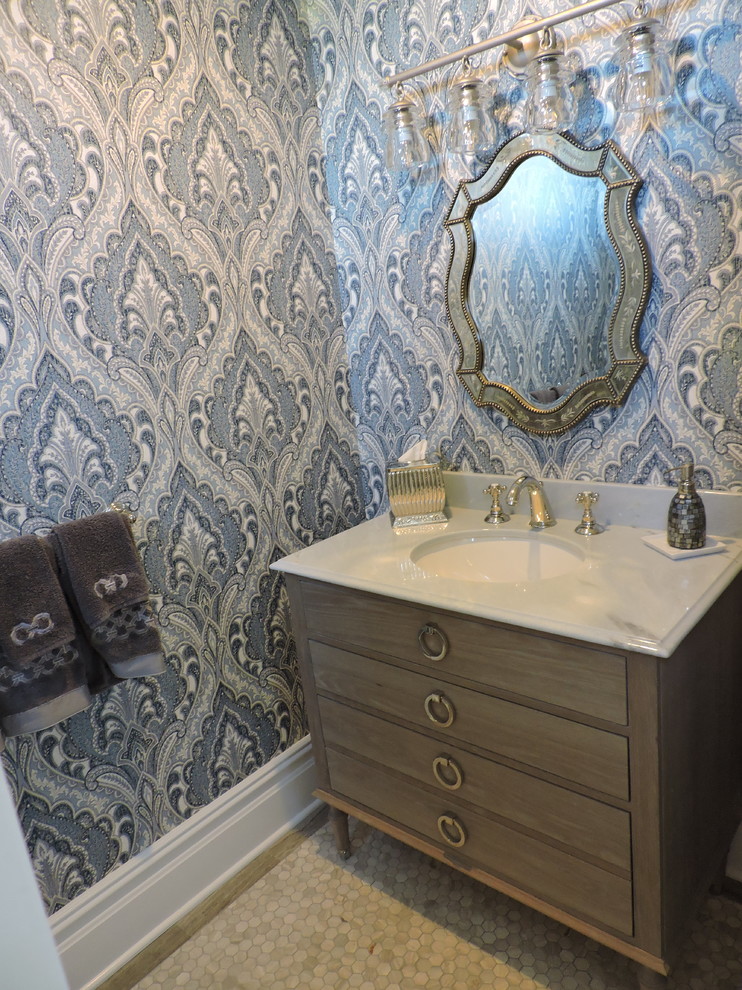 Esempio di un bagno di servizio classico di medie dimensioni con consolle stile comò, ante in legno chiaro, pareti blu, pavimento in gres porcellanato, top in marmo, pavimento beige e top bianco