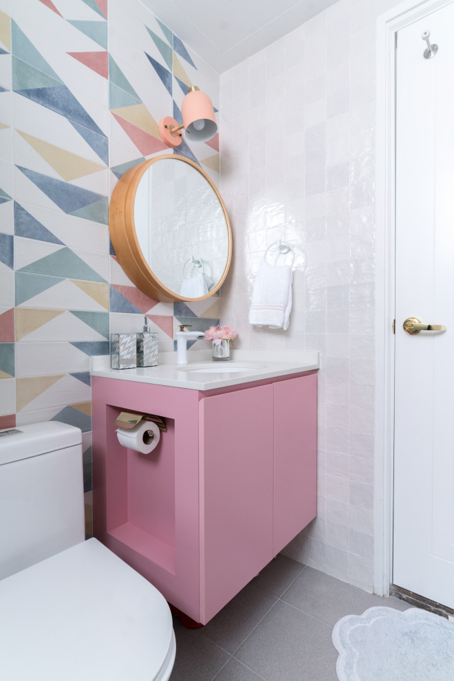 Inspiration pour un WC et toilettes design avec un placard à porte plane, un carrelage multicolore, un lavabo encastré, un sol gris et un plan de toilette blanc.