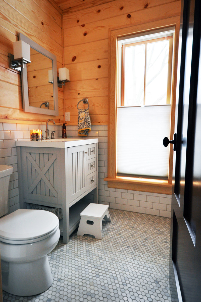 Exemple d'un WC et toilettes nature avec un lavabo encastré, WC séparés, un carrelage gris, un sol en carrelage de porcelaine et un carrelage métro.