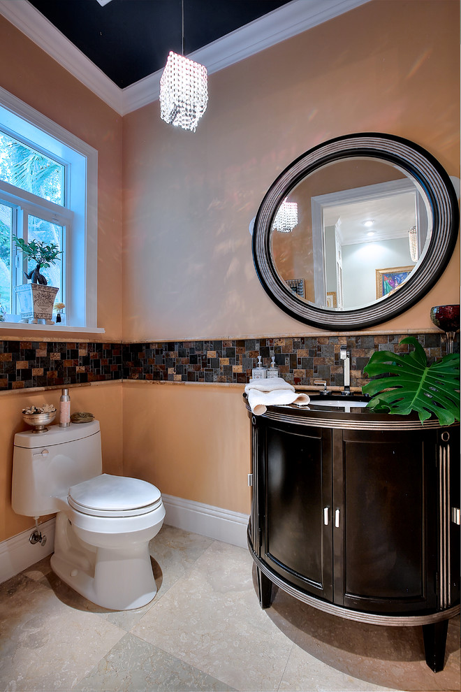 На фото: туалет в стиле неоклассика (современная классика) с врезной раковиной, фасадами с утопленной филенкой, черными фасадами, унитазом-моноблоком и коричневой плиткой