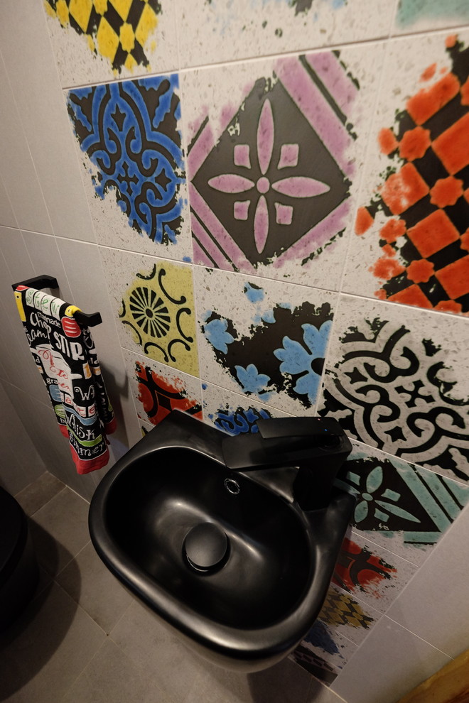 Idee per un piccolo bagno di servizio minimal con WC a due pezzi, piastrelle multicolore, piastrelle in gres porcellanato, pareti grigie, lavabo sospeso, pavimento grigio e top nero