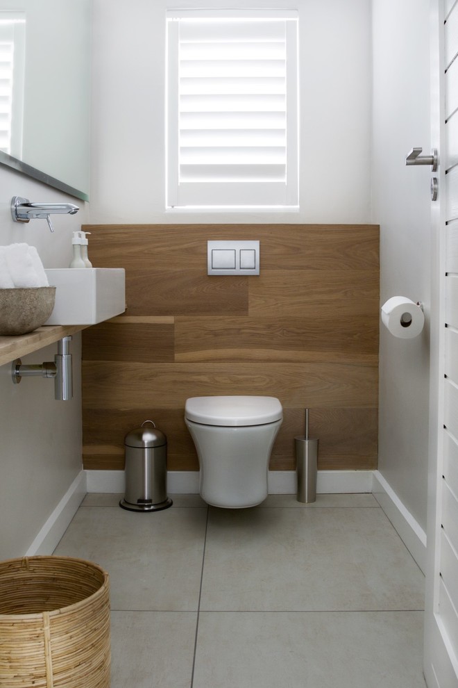 Medium sized contemporary cloakroom in Other with open cabinets, light wood cabinets, a wall mounted toilet, beige walls, porcelain flooring, a vessel sink and wooden worktops.