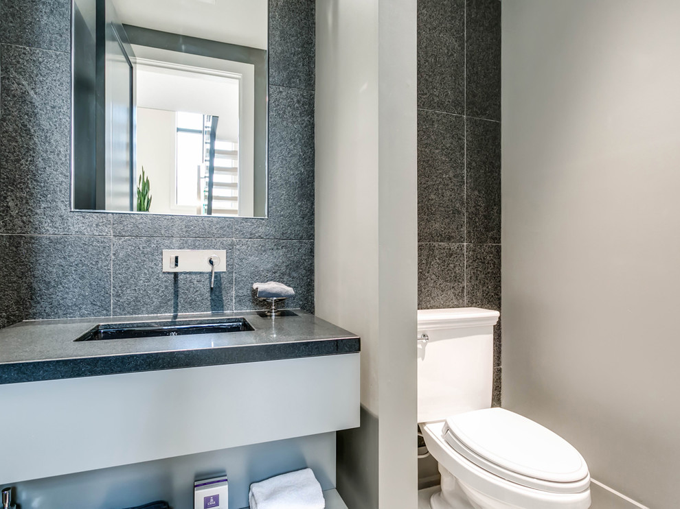 Design ideas for a small contemporary cloakroom in Toronto with grey cabinets, a one-piece toilet, black tiles, grey walls, an integrated sink and black worktops.