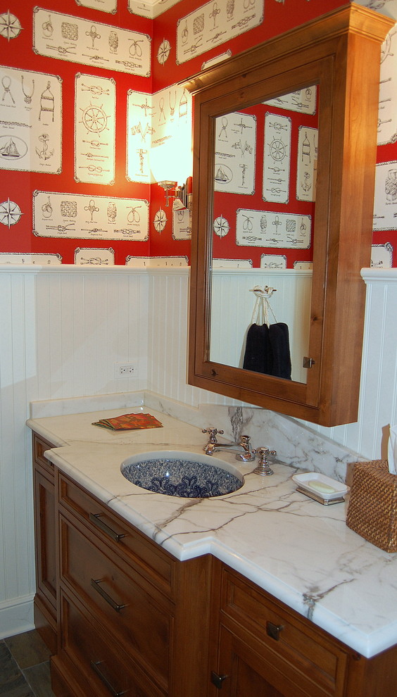 Foto di un bagno di servizio minimal di medie dimensioni con lavabo sottopiano, ante in legno scuro, top in marmo, pareti multicolore e ante con riquadro incassato