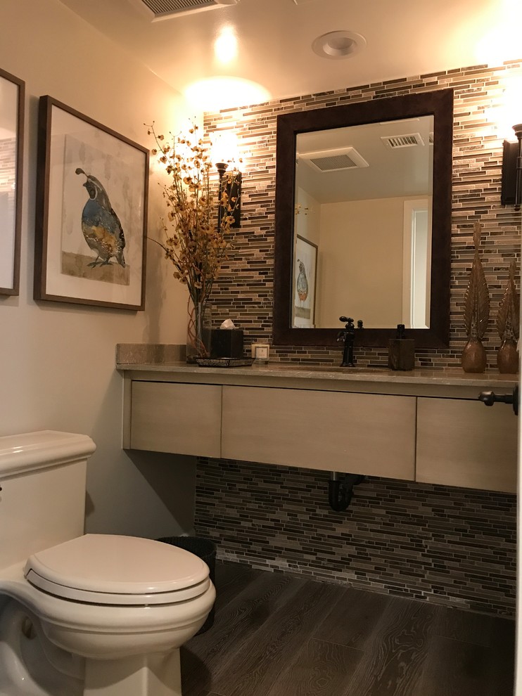 Design ideas for a large classic cloakroom in Orange County with a one-piece toilet, multi-coloured tiles, glass tiles, beige walls, dark hardwood flooring, a submerged sink and brown floors.