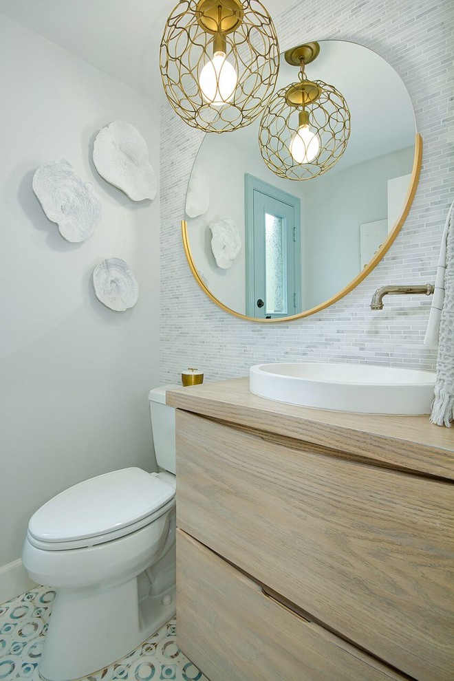 Inspiration for a classic cloakroom in Orange County with flat-panel cabinets, light wood cabinets, a two-piece toilet, grey tiles, white tiles, grey walls, a vessel sink, wooden worktops, multi-coloured floors and brown worktops.