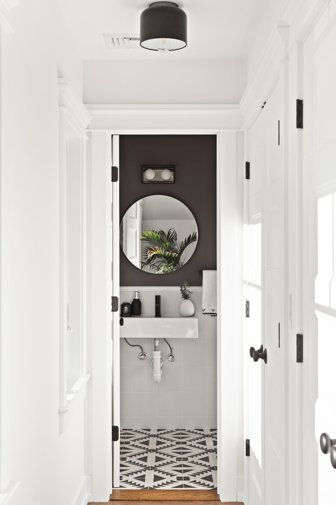 Example of a transitional white tile multicolored floor powder room design in New York with black walls and a wall-mount sink