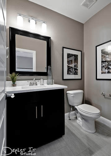 Réalisation d'un WC et toilettes design en bois foncé de taille moyenne avec un placard avec porte à panneau encastré, WC séparés, un carrelage gris, un mur gris et un lavabo encastré.
