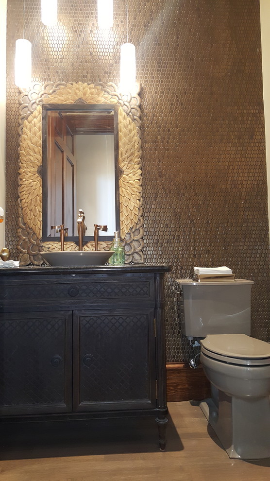 Example of a large classic metal tile light wood floor powder room design in Houston with furniture-like cabinets, a two-piece toilet, brown walls, a vessel sink, granite countertops and dark wood cabinets